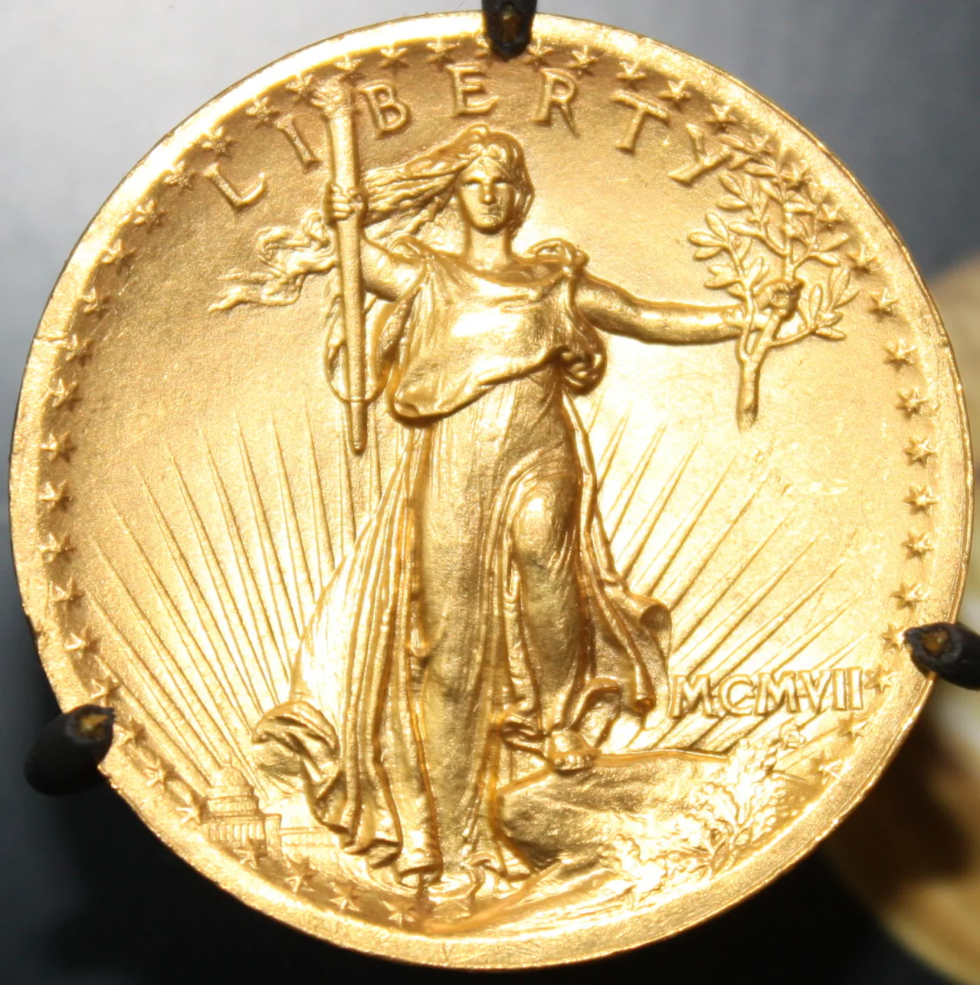 Obverse of a 1907 High Relief Saint-Gaudens double eagle with Liberty striding forward and the date written in Roman numerals as MCMVII at lower right