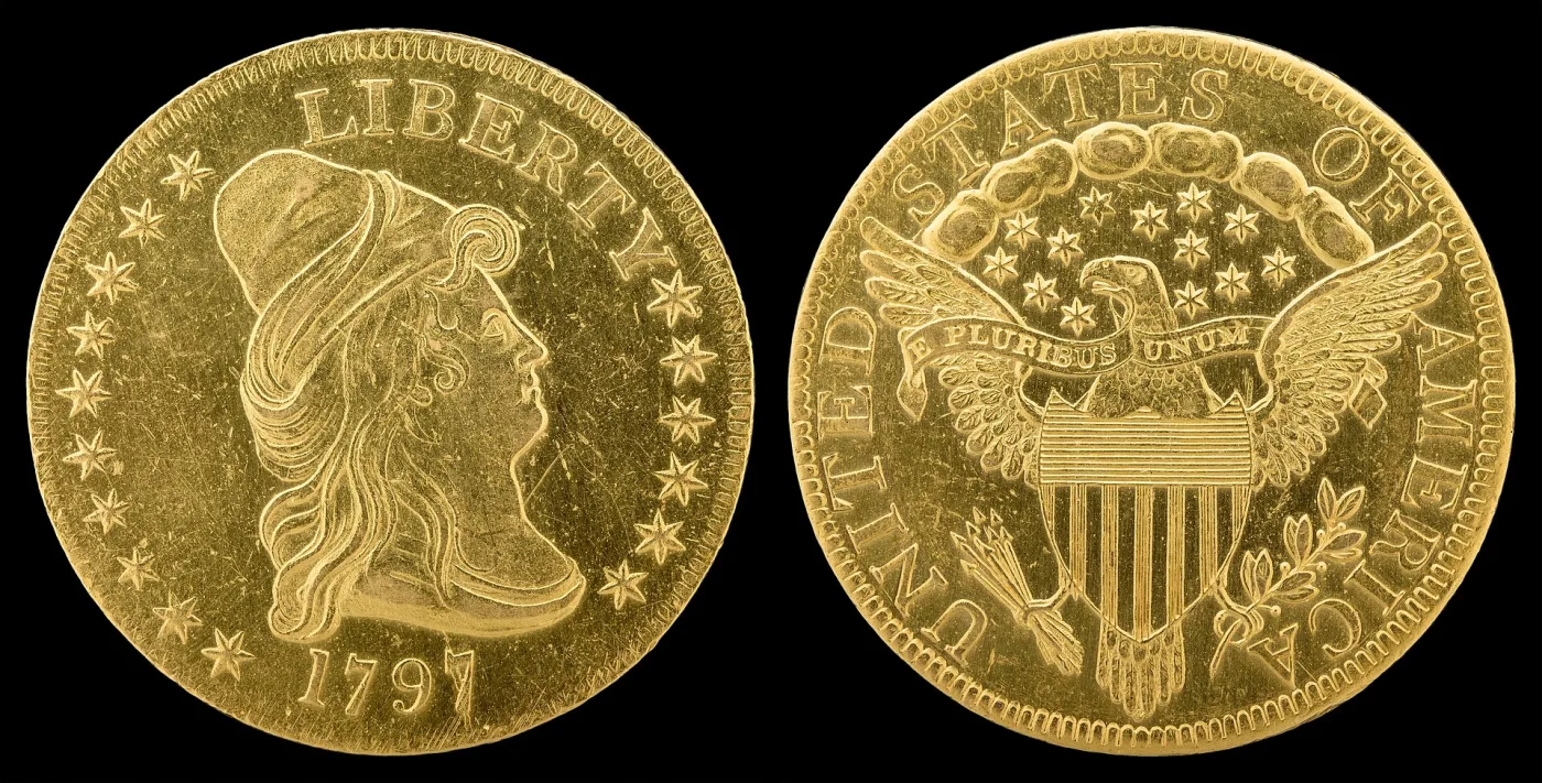 Obverse and reverse of a gold eagle dated 1797, the reverse showing the heraldic eagle with a striped shield, banner motto and stars above