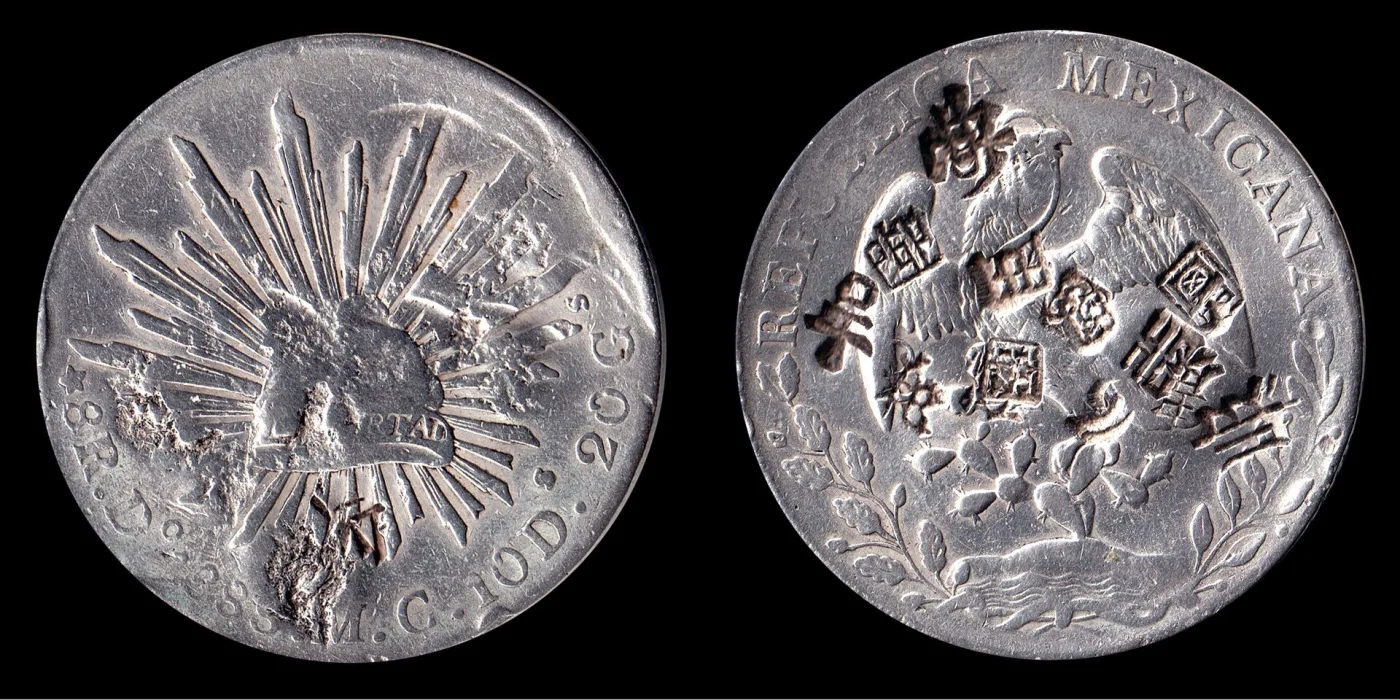 Obverse and reverse of a Mexican silver eight reales coin, the surfaces scattered with small punched Chinese characters that overlap the original design