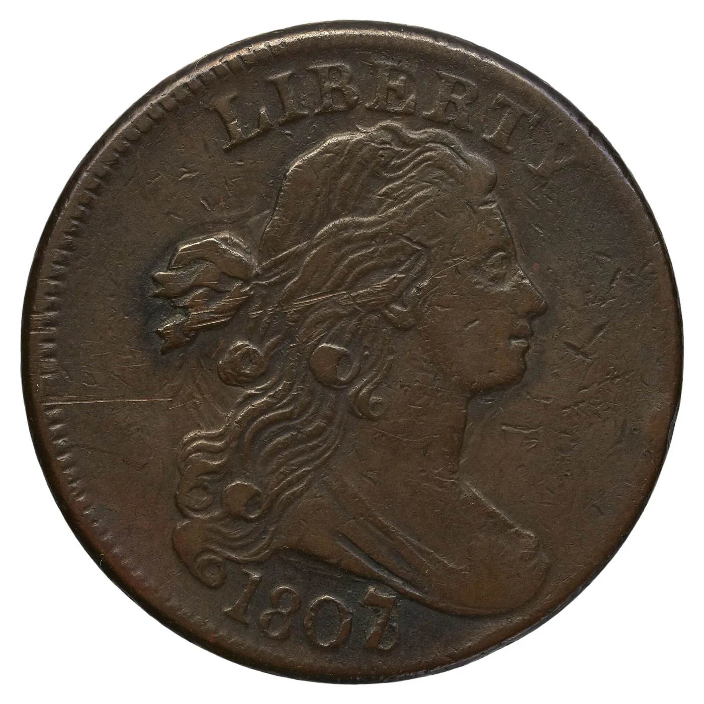 Obverse of an 1807 Draped Bust large cent with fine scratches across the field, LIBERTY arched above the portrait and the date 1807 below the bust