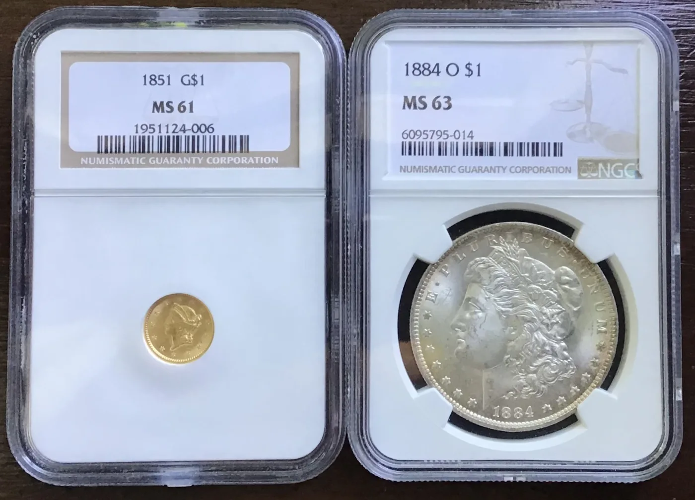 Two identical NGC holders side by side, the left one containing a tiny 1851 Type 1 gold dollar and the right one an 1884-O Morgan silver dollar that fills its window