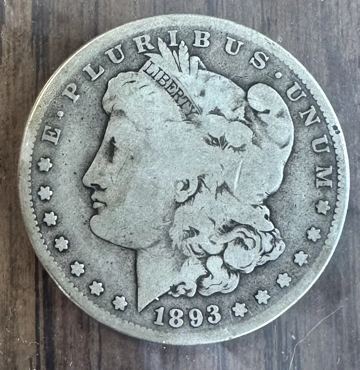 Obverse of a heavily circulated 1893 Morgan dollar, the portrait worn nearly smooth with the date still bold at the bottom