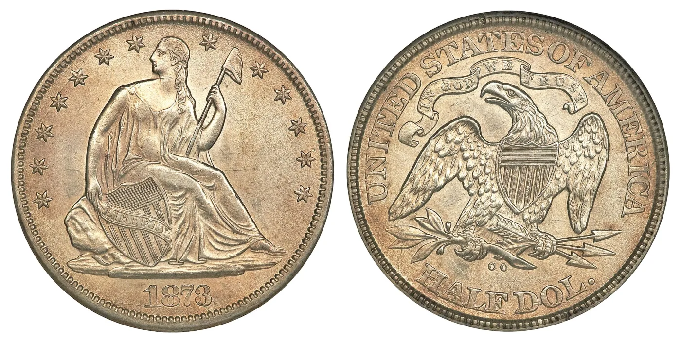 Both sides of an 1873-CC Seated Liberty half dollar without arrows at the date, the reverse carrying the motto and a CC mint mark