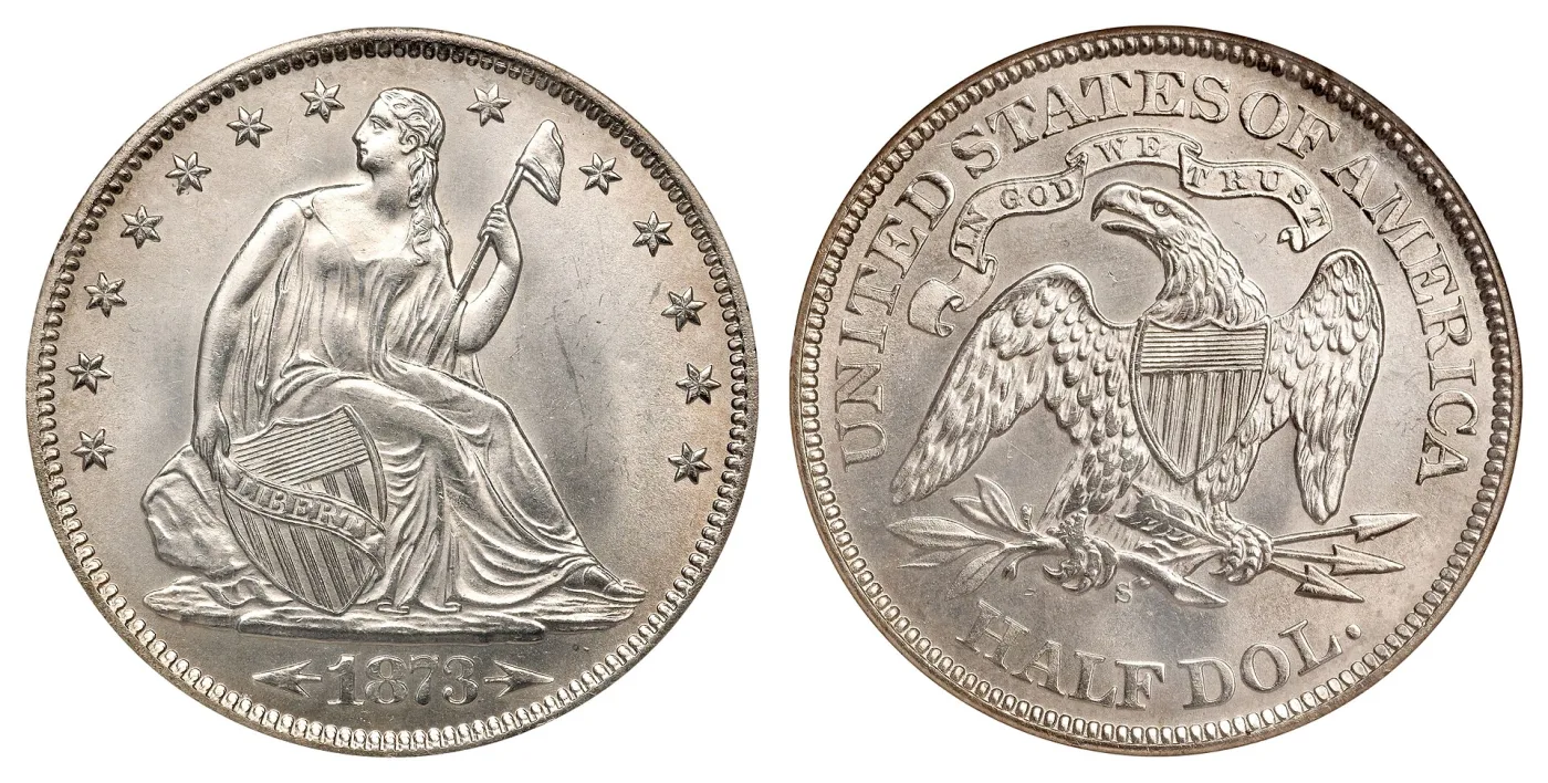 Both sides of an 1873-S Seated Liberty half dollar with arrows at the date, the reverse carrying the motto and an S mint mark